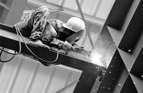 An employee engaged in welding work at Fujian Dongshan Glass Factory. The Ministry of Industry and Information Technology expects an average annual industrial output growth rate of 10 percent and a reduction in energy consumption and carbon emissions per unit of output by 16 percent in the next five years. [China Daily]