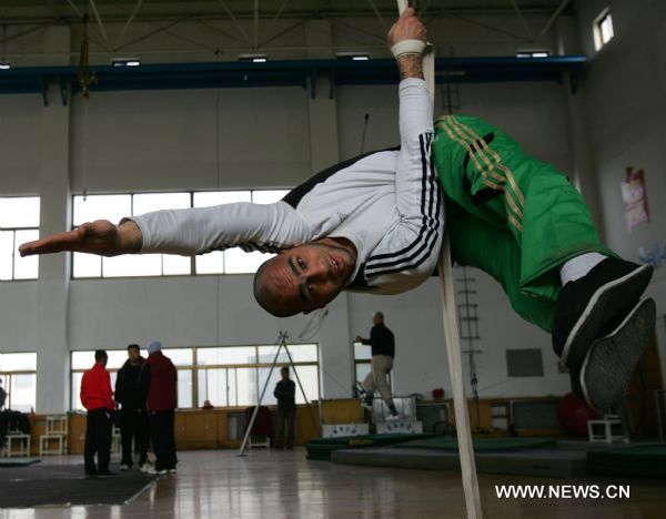 Belal from Egypt practises basic motions of acrobatics at Wuqiao acrobatic art school in Wuqiao County, north China's Hebei Province, Dec. 23, 2010. 