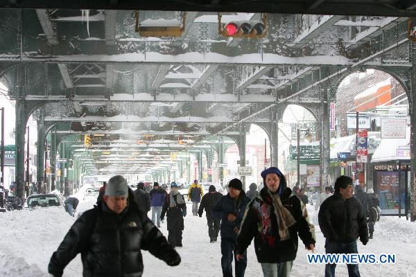 People walk on the snow-covered Roosevelt street after a blizzard in the New York City borough of Queens on Dec. 27, 2010. 