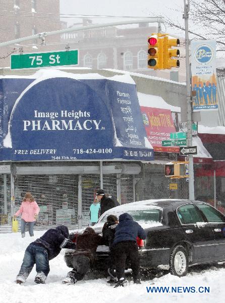 People try to free a stranded car after a blizzard in the New York City borough of Queens on Dec. 27, 2010. 