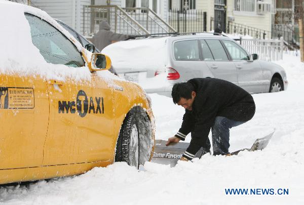 A man tries to free the stranded taxi after a blizzard in the New York City borough of Queens on Dec. 27, 2010.