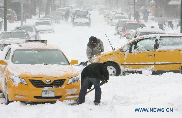 Taxi drivers try to free their stranded vehicles after a blizzard in the New York City borough of Queens on Dec. 27, 2010.