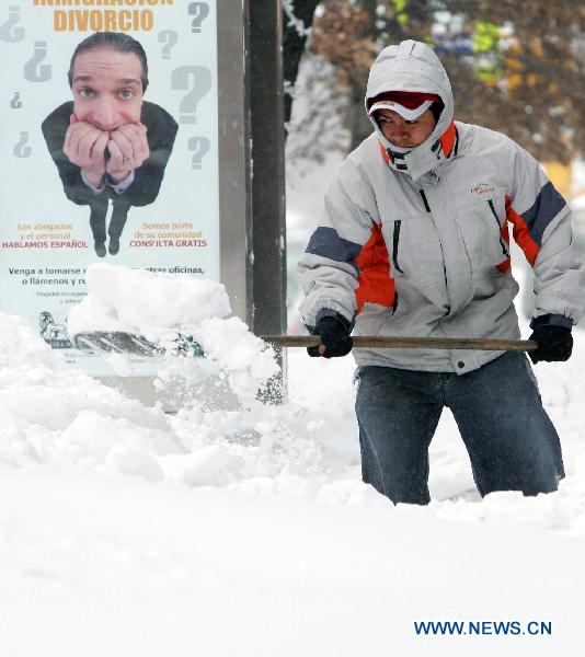 A man shovels snow from the sidewalk after a blizzard in the New York City borough of Queens on Dec. 27, 2010. 