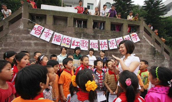 Workers from a local community in Yongchuan district, Chongqing municipality, sing revolutionary songs with children left behind by parents working away from home at a local school on May 26. The circulation among the public of revolutionary songs is one of the reasons Chongqing was named one of China's 10 happiest cities this year.
