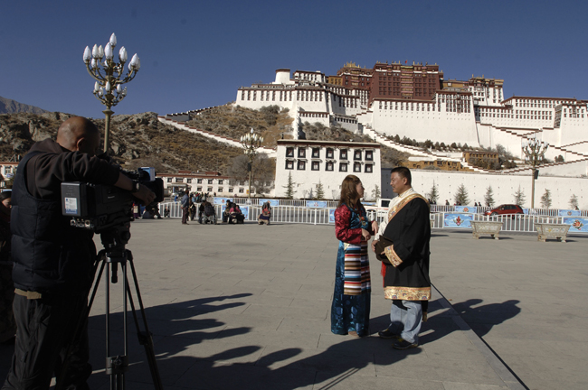 A pair of newlywed are shot by a cameraman of local TV station, in front of the Potala Palace in Lhasa, capital of southwest China&apos;s Tibet Autonomous Region, Dec. 28, 2010. A total of ten pairs of newly married couples who were selected from thousands of candidates nation wide took part in a group wedding in Tibet recently. [Xinhua]