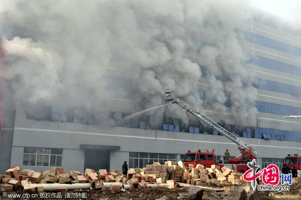 Firefighters work at the fire site on December 28, 2010 in Yiwu, southeast China&apos;s Zhejiang Province. The warehouse of the Langsha Group catches fire on Tuesday. The cause of the fire is under investigation and no reports of injuries. [CFP]