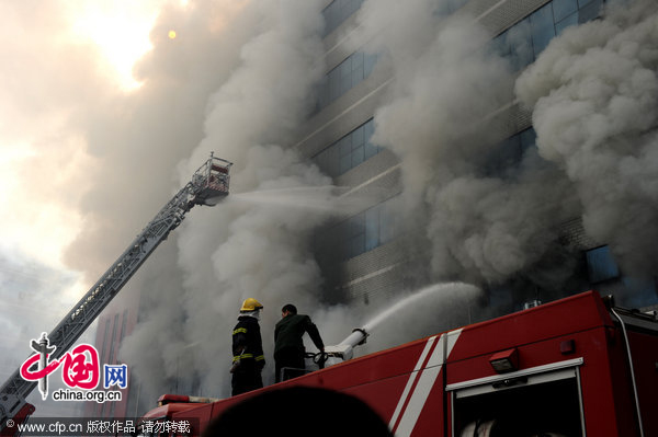 Firefighters work at the fire site on December 28, 2010 in Yiwu, southeast China&apos;s Zhejiang Province. The warehouse of the Langsha Group catches fire on Tuesday. The cause of the fire is under investigation and no reports of injuries. [CFP]