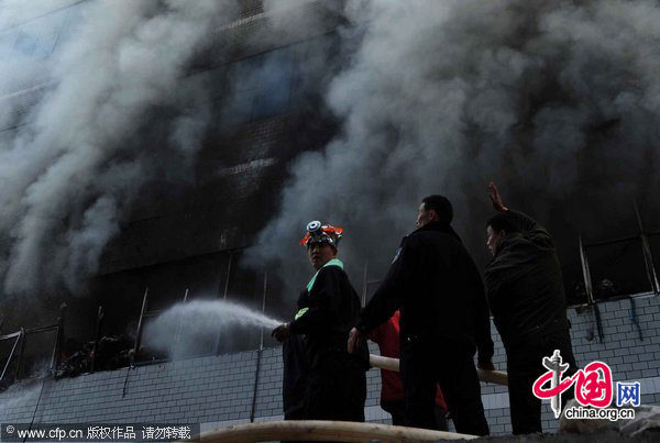 Firefighters work at the fire site on December 28, 2010 in Yiwu, southeast China&apos;s Zhejiang Province. The warehouse of the Langsha Group catches fire on Tuesday. The cause of the fire is under investigation and no reports of injuries. [CFP]