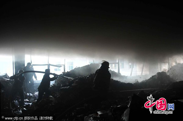 Firefighters work at the fire site on December 28, 2010 in Yiwu, southeast China&apos;s Zhejiang Province. The warehouse of the Langsha Group catches fire on Tuesday. The cause of the fire is under investigation and no reports of injuries. [CFP]