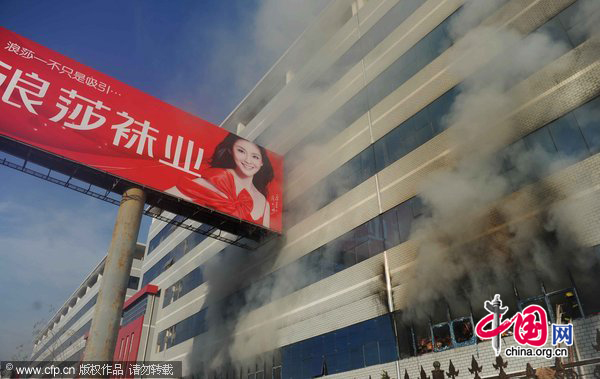 Firefighters work at the fire site on December 28, 2010 in Yiwu, southeast China&apos;s Zhejiang Province. The warehouse of the Langsha Group catches fire on Tuesday. The cause of the fire is under investigation and no reports of injuries. [CFP]