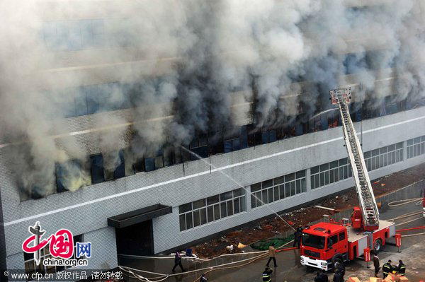 Firefighters work at the fire site on December 28, 2010 in Yiwu, southeast China&apos;s Zhejiang Province. The warehouse of the Langsha Group catches fire on Tuesday. The cause of the fire is under investigation and no reports of injuries. [CFP]