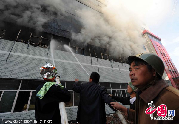 Firefighters work at the fire site on December 28, 2010 in Yiwu, southeast China&apos;s Zhejiang Province. The warehouse of the Langsha Group catches fire on Tuesday. The cause of the fire is under investigation and no reports of injuries. [CFP]