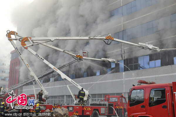 Firefighters work at the fire site on December 28, 2010 in Yiwu, southeast China&apos;s Zhejiang Province. The warehouse of the Langsha Group catches fire on Tuesday. The cause of the fire is under investigation and no reports of injuries. [CFP]