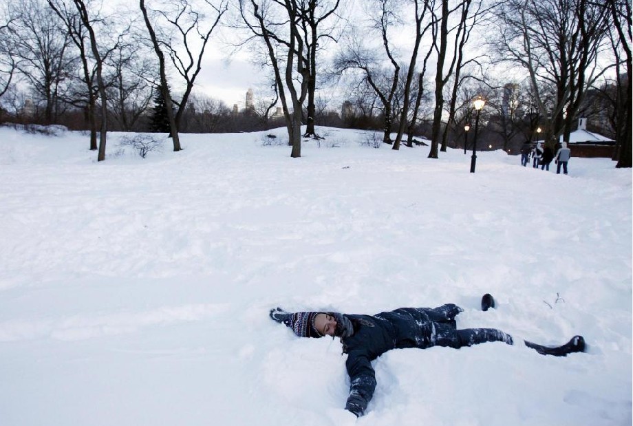 A girl makes a snow angel in New York&apos;s Central Park, Dec 27, 2010. A blizzard pummeled the northeastern United States on Monday, burying cities in knee-deep snow, leaving thousands camped at airports and snarling traffic with blowing snow and icy roads at the end of the busy Christmas weekend. [China Daily/Agencies]