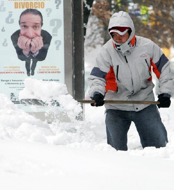 A man is busy with clearing snow in front of his house in New York, Dce 27, 2010. [Xinhua]