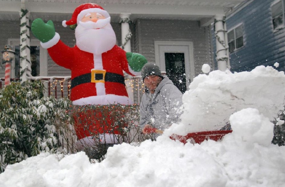 Shawn Keefe clears snow from the front of a residence during a snowstorm in Somerville, Massachusetts Dec 27, 2010. [China Daily/Agencies]