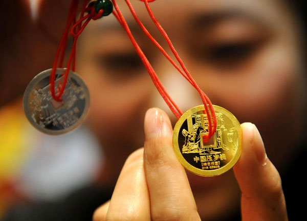 The golden coin of the new gift money is shown at Caibai Mall in Beijing, Dec 28, 2010. [Xinhua]