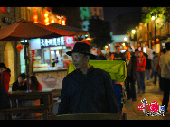 Photo show the night scenery of Nanhou street, a street well known for its ancient architecture in Fuzhou City, China's Fujian Province. The street is lined with some shops with ethnic flavor. These shops do business by selling specialties and ethnic goods like Taiwan food, minority trappings. [Photo by Zhou Yunjie]