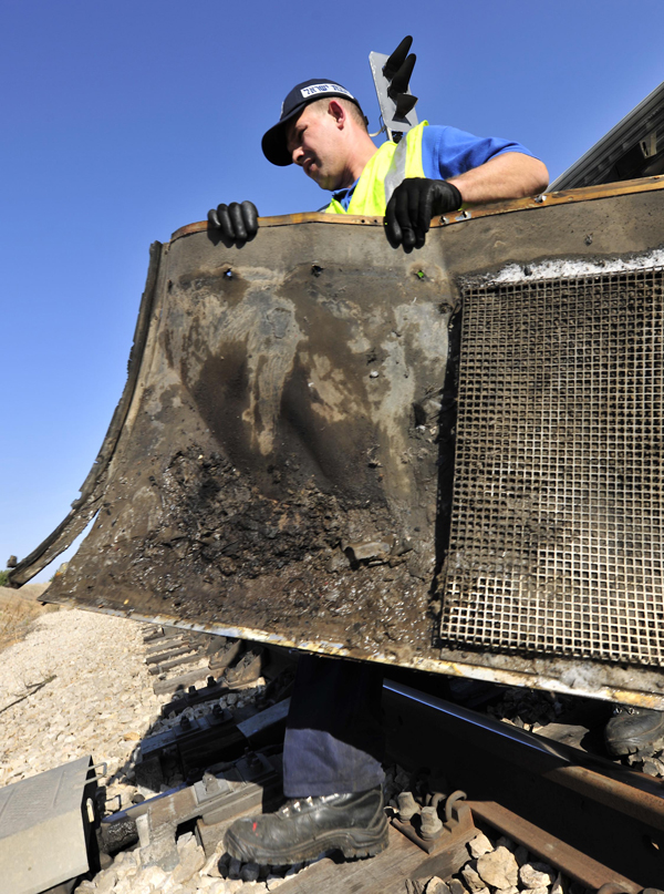 An Israeli firefighter carries remains of a burnt passenger train near Shefayim, Israel. A fire broke out on a train near the central Israeli town of Shfayim on Tuesday morning, injuring dozens of passengers, local media reported.