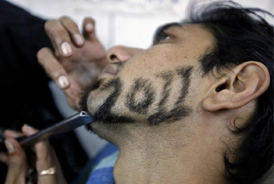 A man has his beard trimmed in the shape of number 2011 to welcome the New Year inside a barbershop in the western Indian city of Ahmedabad Dec 29, 2010. [China Daily/Agencies]