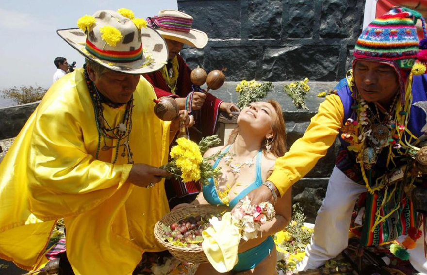 A woman holds an offering of fruits as shamans perform a ritual for good luck for the new year in Lima Dec 29, 2010. [China Daily/Agencies] 