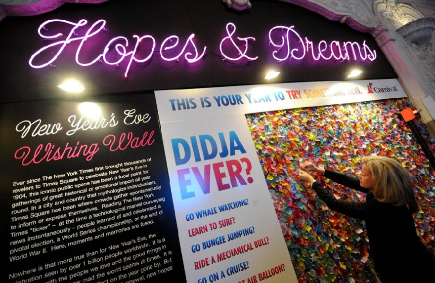 A woman pins her hopes and dreams on a wish wall at Times Square in New York, Dec 29, 2010. [China Daily/Agencies]