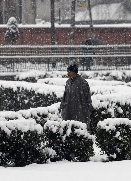 A Kashmiri man walks during the winter season&apos;s first snowfall in Srinagar Dec 30, 2010. [China Daily/Agencies] 