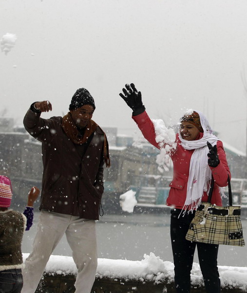 A Indian tourist couple playfully tosses snow at each other during the winter season&apos;s first snowfall in Srinagar Dec 30, 2010. [China Daily/Agencies]