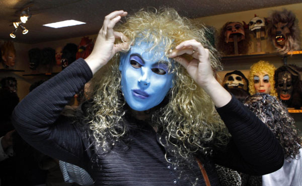 A customer puts on an Avatar mask at a shop in Quito Dec 29, 2010. Ecuadoreans burn puppets and wear masks to celebrate the end of the year. [China Daily/Agencies]