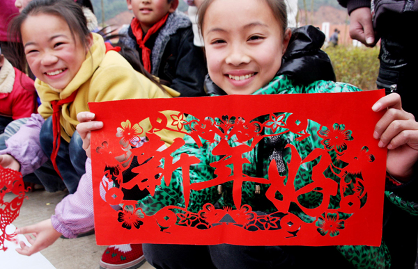 Students show their paper-cutting works during a traditional Chinese paper cutting activity for the upcoming new year in Dexing, Jiangxi Province, Dec. 30, 2010. Paper-cutting works are usually used to decorate doors and windows. [Xinhua photo]