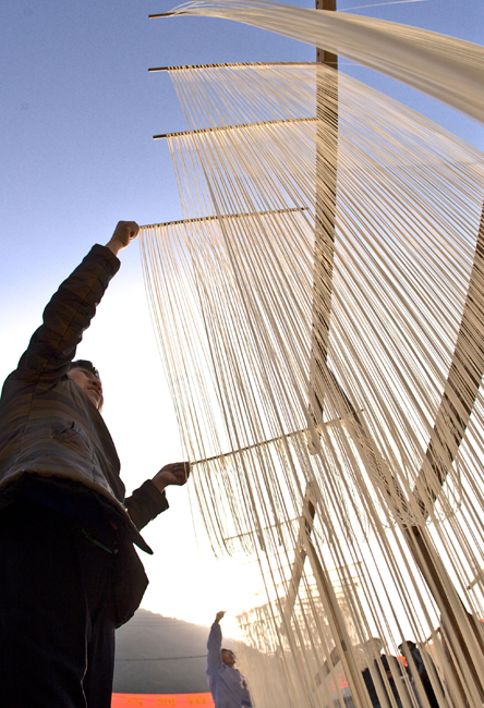 A woman dries handmade noodles in Majian Township of Zhuji City, east China&apos;s Zhejiang Province, Dec. 30, 2010. A handmade noodle making contest was held here on Thursday. The handmade noodles of Majian Township are famous for the length. Long noodles symbolize longevity in Chinese tradition. [Xinhua]