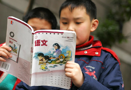 Two primary school students in Shanghai read a language textbook. 