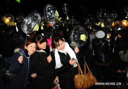 Girls wait to release the balloons during the New Year celebrations at the Zojoji temple in Tokyo, Japan, Dec. 31, 2010. [Xinhua/Ji Chunpeng] 