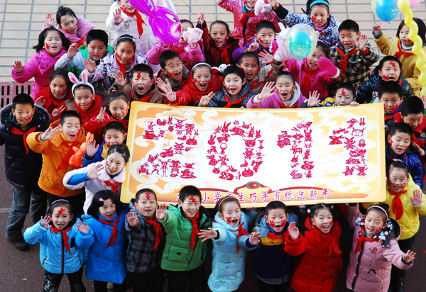 Students show their paper cutting works during a traditional Chinese paper cutting activity for the upcoming new year in Jiujiang, east China's Jiangxi Province, Dec. 31, 2010. [Xinhua photo]