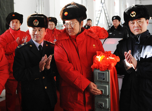 Yao Wei (C), general manager of the Pipeline Branch of Petro China Co Ltd (PBPC), pushes a button to make the pipeline begin operating at a plant in Mohe county, Northeast China's Heilongjiang province, Jan 1, 2011. [Xinhua]