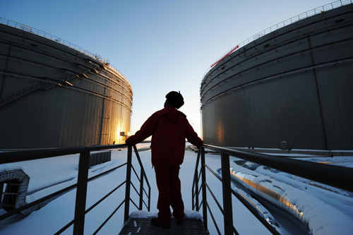 A worker inspects the oil tanks at a plant in Mohe county, northeast China's Heilongjiang province, Jan 1, 2011. [Xinhua]