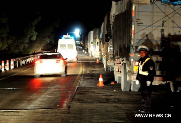 A policeman directs vehicles on China National Highway 210 in Hechi City, south China's Guangxi Zhuang Autonomous Region, Jan. 2, 2011. A section of China National Highway 210 in Guizhou Province was closed due to freezing rain, causing some 1,500 vehicles stranded and leaving more than 7,000 passengers trapped in Nandan County of Guangxi as of 5 p.m. on Sunday. (Xinhua/Huang Xiaobang) (zgp) 