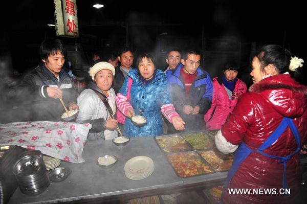 Stranded passengers eat at a roadside restaurant in Hechi City, south China's Guangxi Zhuang Autonomous Region, Jan. 2, 2011. A section of China National Highway 210 in Guizhou Province was closed due to freezing rain, causing some 1,500 vehicles stranded and leaving more than 7,000 passengers trapped in Nandan County of Guangxi as of 5 p.m. on Sunday. (Xinhua/Huang Xiaobang) (zgp) 