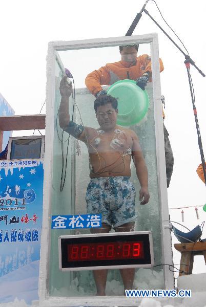 Chinese &apos;Iceman&apos; Jin Songhao stands in a plastic box while a assistant puts in ice cubes during a cold endurance competition in Zhangjiajie, central China&apos;s Hunan Province, Jan. 3, 2010. 