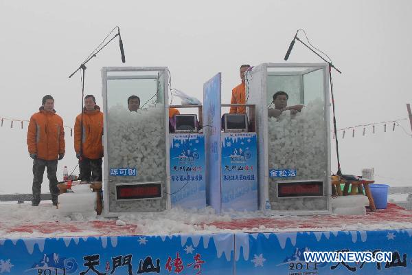 Chinese &apos;Icemen&apos; Chen Kecai (L, Front) and Jin Songhao (R, Font) stand immersed in ice during a cold endurance competition in Zhangjiajie, central China&apos;s Hunan Province, Jan. 3, 2010. [Xinhua]