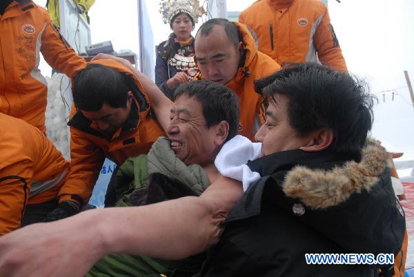 Chinese &apos;Iceman&apos; Chen Kecai (C) is carried out of the ice tank during a cold endurance competition in Zhangjiajie, central China&apos;s Hunan Province, Jan. 3, 2010. [Xinhua]