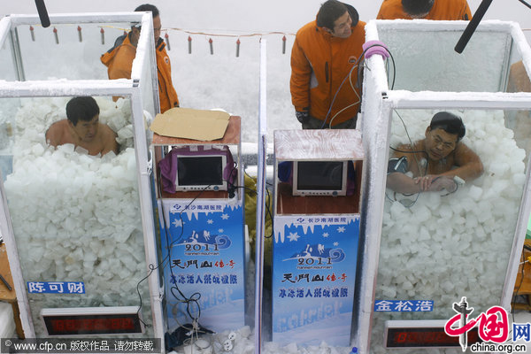 Chinese &apos;Icemen&apos; Chen Kecai (L, Front) and Jin Songhao (R, Font) stand immersed in ice during a cold endurance competition in Zhangjiajie, central China&apos;s Hunan Province, Jan. 3, 2010. [CFP]
