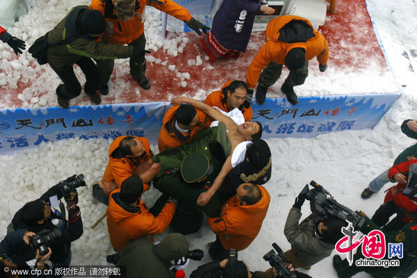 Chinese &apos;Iceman&apos; Chen Kecai (C) is carried out of the ice tank during a cold endurance competition in Zhangjiajie, central China&apos;s Hunan Province, Jan. 3, 2010. [Xinhua]
