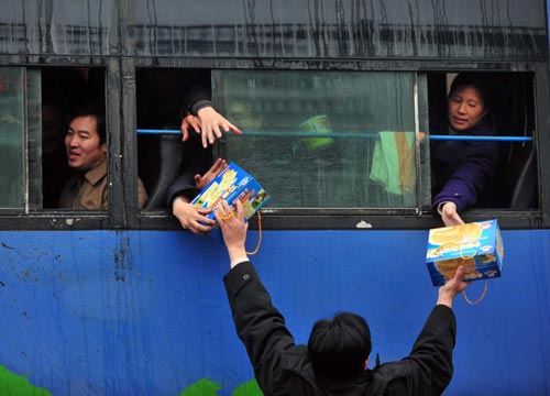 Rescuers distribute food to passengers in a coach stranded on a expressway in Nandan county, South China&apos;s Guangxi Zhuang autonomous region, Jan 3, 2011. [Xinhua] 