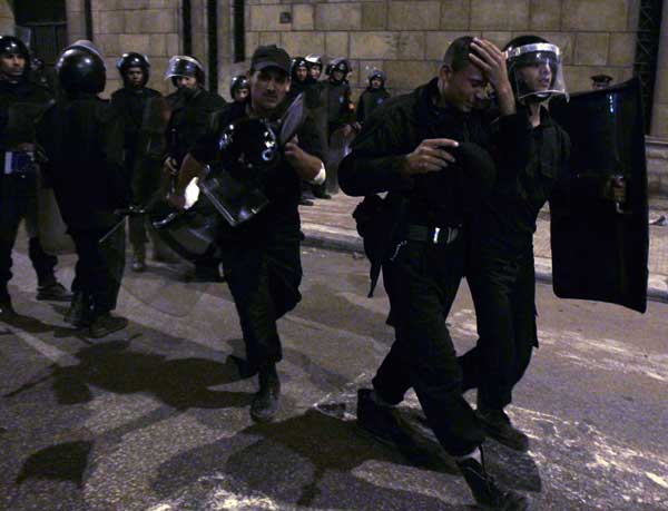 Riot police assist a colleague during clashes with Egyptian Christians in front of al-Abasseya Cathedral in Cairo late night January 2, 2011. Angry Coptic Christians clashed with police on Sunday as they demanded more protection for Egypt&apos;s Christians following a New Year&apos;s Day church bombing that killed 21 of their brethren. Picture taken January 2, 2011. [Xinhua/Reuters] 