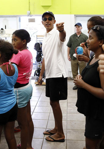 US President Barack Obama points while waiting in line at a shave ice shop in Kailua, Hawaii Jan 3, 2011. [China Daily/Agencies]