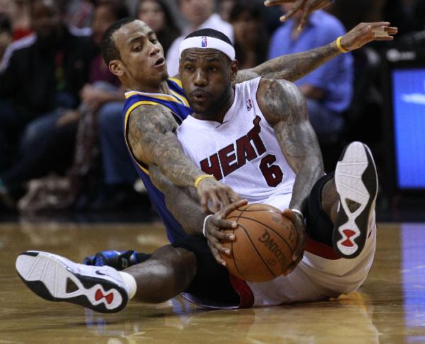 Miami Heat's LeBron James (R) battles for a loose ball against Golden State Warriors' Monta Ellis during third quarter NBA basketball action in Miami January 1, 2011. (Xinhua/Reuters Photo)