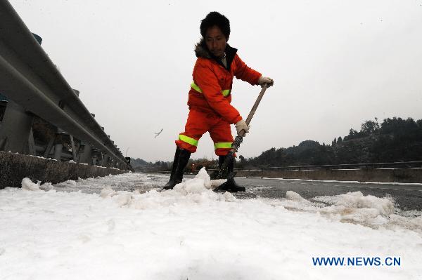 People clear ice on a highway in central China's Hunan province on Jan. 3, 2011. China's Ministry of Public Security Monday enacted emergency procedures to cope with freezing rain in the nation's southern provinces, aiming to restart road traffic which often came to a halt because of icy roads. The Ministry urged local authorities in Guizhou, Guangxi and Hunan provinces to prevent passengers from again being stranded due to icy rain and freezing temperatures, according to a statement. 