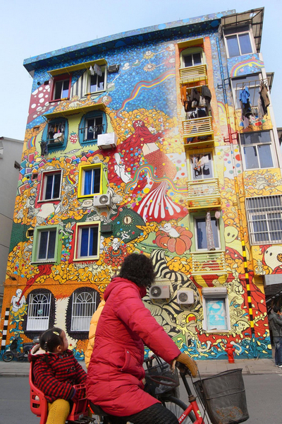 An outdoor mural attracts passers-by in Hangzhou, capital city of East China&apos;s Zhejiang province, Jan 4, 2011. Located on Shentangqiao Road, the huge artwork on the five-story building was created in one month and its theme is &apos;Nervous.&apos; [Xinhua]