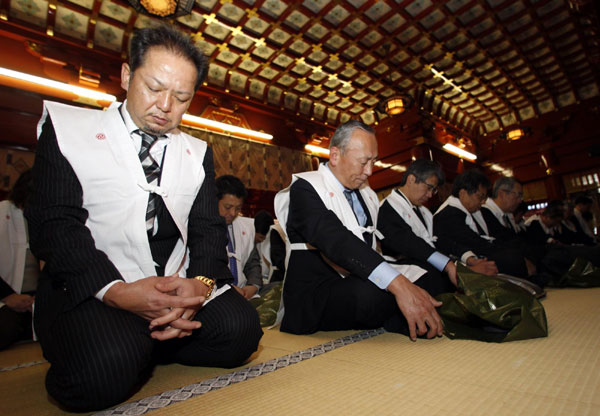 Japanese corporate executives wearing sacred Shinto vests offer prayers for success in their business in the coming new year on the first business day of 2011 for Japan at Kanda Myojin shrine in Tokyo Jan 4, 2011. [China Daily/Agencies]